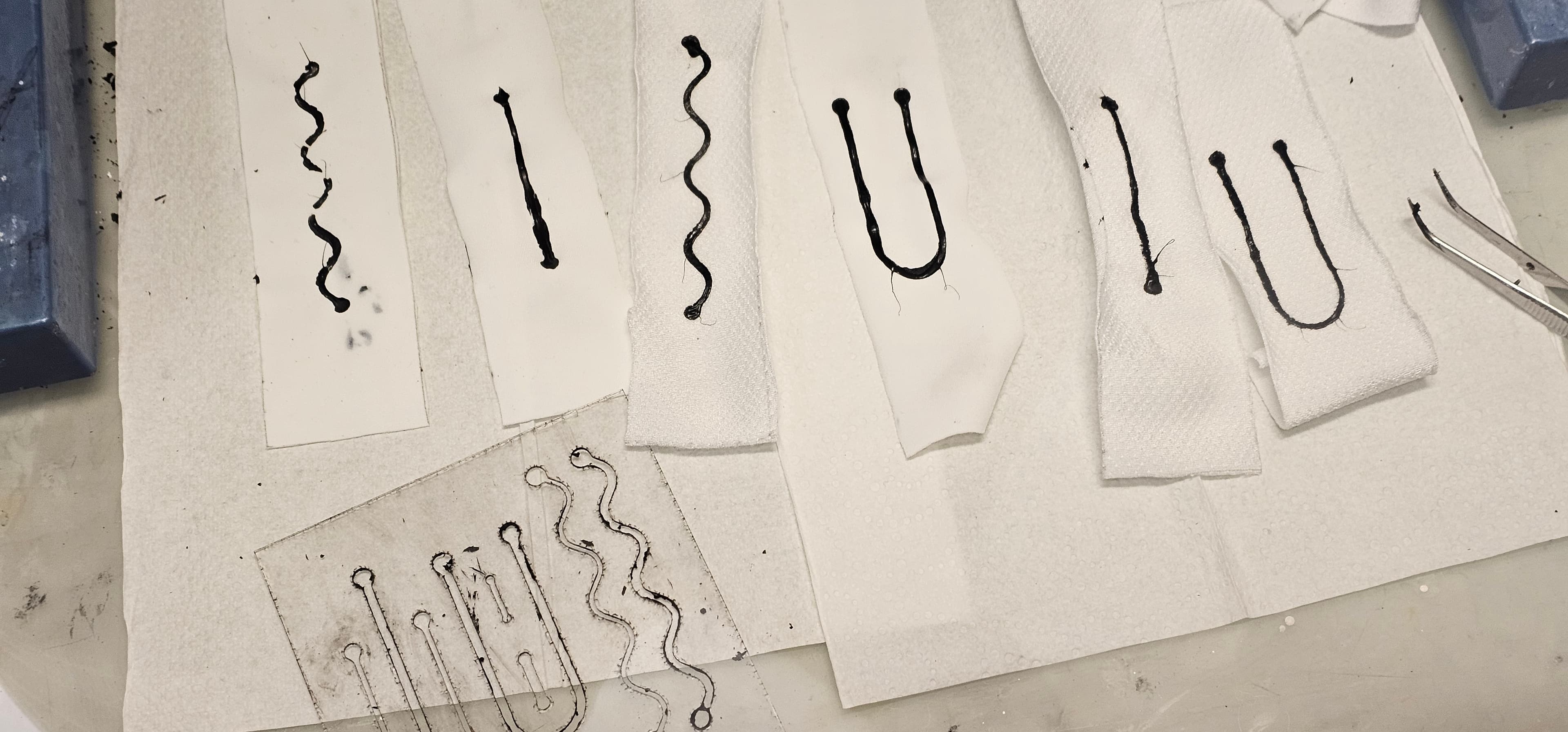 Liquid printed sensors over a two way stretch fabric using stencils